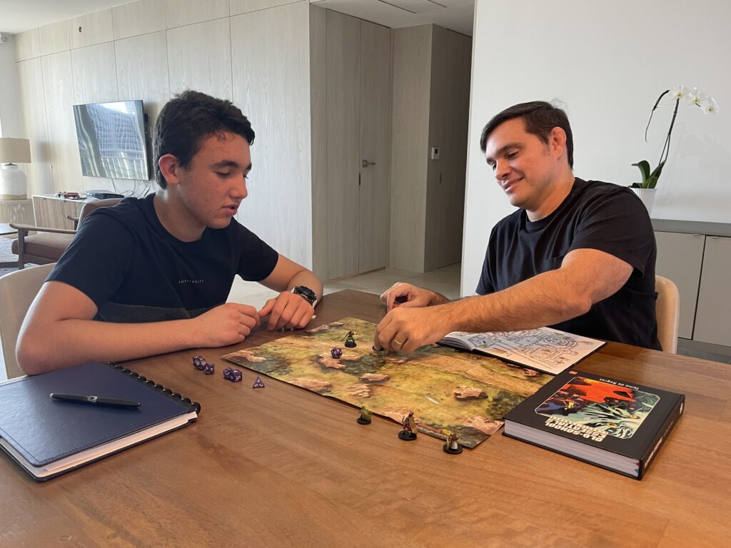 Henry Miranda, Founder of Fantastic Art Studios, plays RPG game with his son.